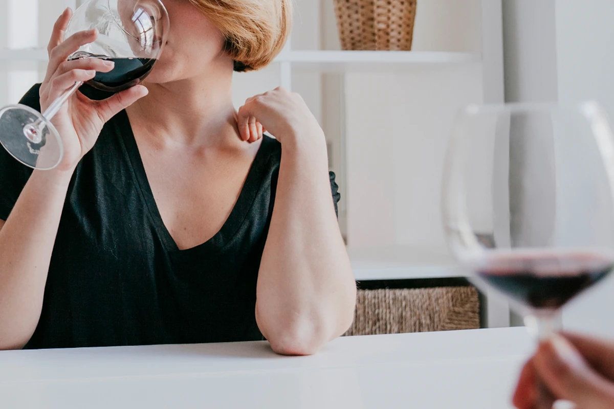 Fazy rozwoju alkoholizmu - kobieta pijąca wino, co ilustruje etap, w którym alkohol staje się codziennym rytuałem