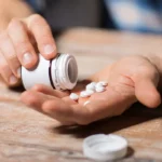 Leczenie lekomanii - ilustracja w formie dłoni trzymających lekarstwa