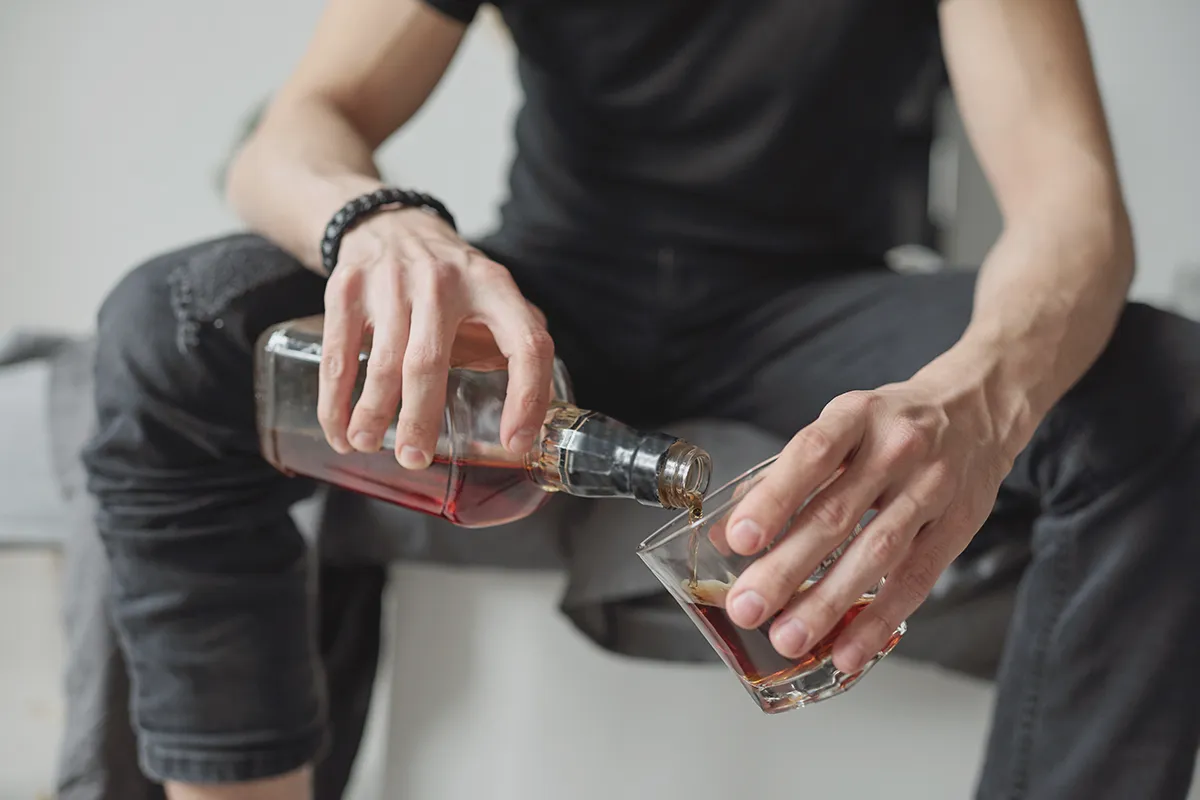 Fazy rozwoju alkoholizmu - kobieta pijąca wino, co ilustruje etap, w którym alkohol staje się codziennym rytuałem